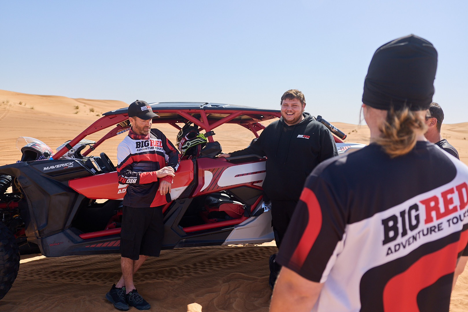 Big Red Adventure Tours team with Can-Am Maverick buggy in the Dubai desert