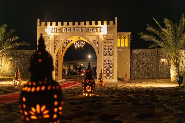The Desert Gate camp entrance lit with lanterns at night in the Dubai desert