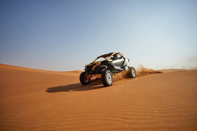 Can-Am Maverick R 2-seater buggy powering up a dune at sunrise on a 2-hour Early Bird tour in Dubai